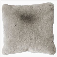 a gray pillow that is on top of a white surface with some black spots in the middle