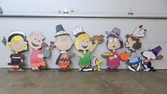 a group of cartoon characters standing next to each other in front of a white wall