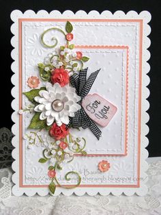 a close up of a greeting card with flowers and ribbon on the front, along with an embellishment