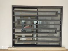 a car is parked in front of a window that has bars on the side and sides