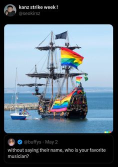 a pirate ship in the water with rainbow flags on it