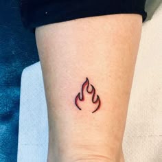 a small fire tattoo on the ankle