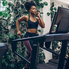 a woman on a treadmill talking on her cell phone and looking at the monitor