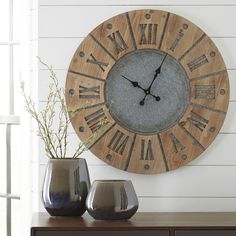 a clock on the wall next to two vases