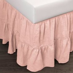 the bed skirt is made from linen and has ruffled edges