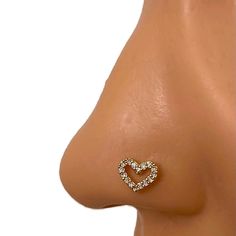 a close up view of the side of a woman's nose with a diamond heart on it