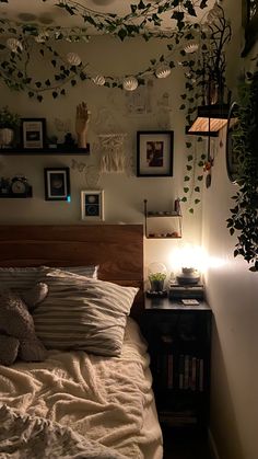 there is a bed with white sheets and pillows in the room that has plants on the wall