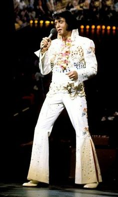 elvis presley singing into a microphone on stage