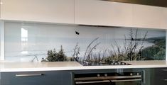 a kitchen with an oven, range and wall mural on the back splash over the stove