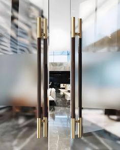 an open door leading to a living room and dining area with marble flooring in the background