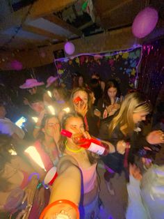 a group of people standing around each other with drinks in their hands and confetti on their mouths