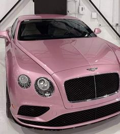 a pink car is parked in a showroom