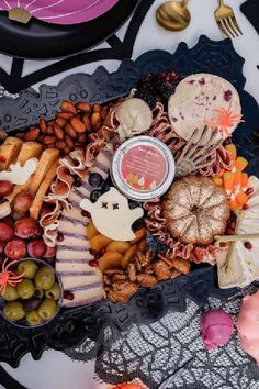 a platter filled with lots of food on top of a table next to plates and utensils