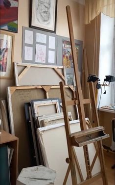 an easel is sitting in front of some paintings