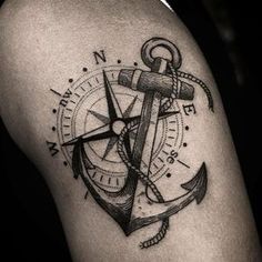 an anchor and compass tattoo on the thigh