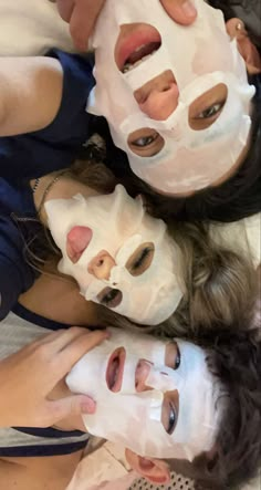 three girls are wearing facial masks on their faces and one girl is covering her face