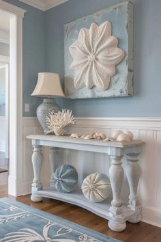 a blue and white living room with an ocean theme on the wall, a large piece of art hanging above it