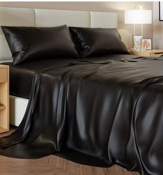 a bed with black leather sheets and pillows