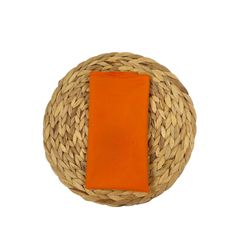 an orange napkin is placed on top of a woven round object that looks like a basket