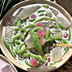 a bowl filled with lots of green beans and other things on top of a table