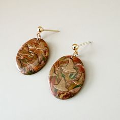 Each pair of Clay + Cause earrings is a hand-made, one of a kind piece! This means your earrings may not be identical to the photograph. Colors and patterns may appear slightly different in person. We can't wait for you to wear your new earrings! Artsy Handmade Drop Earrings, Handmade Artsy Drop Earrings, Handmade Artsy Earrings, Earthy Multicolor Earrings Perfect For Gifts, Earthy Style Drop Earrings For Gift, Earthy Gold Earrings For Gift, Earthy Drop Earrings For Gift, Artsy Brown Earrings With Ear Wire, Earthy Multicolor Earrings For Gift