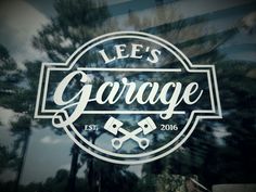 the logo for lee's garage is shown on a glass door with trees in the background