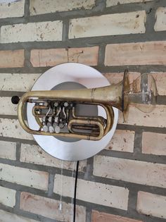 a trumpet mounted to the side of a brick wall