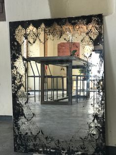 the reflection of a table and chairs in a mirror on the wall behind it is shown