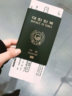 a person holding up a korean passport