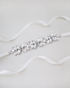 "Ethereally entangled series of butterfly rhinestones attached on bridal white double-faced satin ribbon. Creates sophisticated and romantic finishing touch to your bridal gown, bridesmaids and flower girls. This embellished sash adds a perfect amount of sparkle to create your statement look. DETAIL: Adult Size 108\" Kids Size 78\" Applique size: 7.5\" length, 1.25\" wide HANDMADE IN USA IMPORTED MATERIALS - We DO NOT offer refunds.  Selected items are eligible for EXCHANGE ONLY within 14 days of delivery date. All accessories are FINAL SALE.  - We are not responsible for lost or stolen items during transit. Additional insurance is available upon request. - Stay updated with latest news or promotion as we grow and follow us on the following outlets: Instagram:  http://instagram.com/shop.ka Elegant White Sashes With Rhinestones, White Crystal Bridal Belt For Party, Silver Bridesmaid Sashes Bridal Accessories, Elegant White Bridal Belt With Satin Bow, White Crystal Sash For Formal Occasions, White Crystal Sashes For Formal Occasions, White Crystal Embellished Sash, White Embellished Crystal Sashes, White Crystal Embellished Sashes