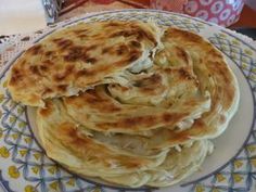 a stack of pancakes sitting on top of a blue and white plate