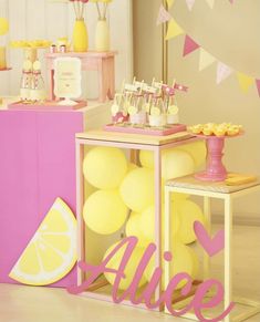 a pink and yellow dessert table with lemons