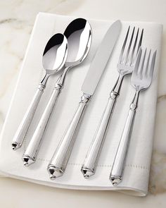 four forks, two spoons and one knife on a white napkin with marble background