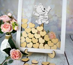 a teddy bear cut out in the shape of hearts next to flowers and a frame