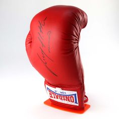 an autographed red boxing glove is on display