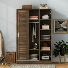 an open closet with clothes and shoes on the floor next to a rug in a room