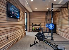 a home gym with an exercise bike, rowing machine and workout equipment on the wall