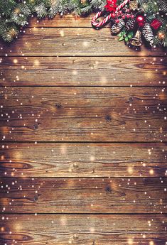 an old wooden background with christmas decorations and pine cones on the bottom right corner, surrounded by lights