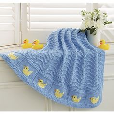 a blue knitted blanket with rubber ducks on it