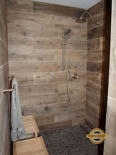 a walk in shower sitting next to a wooden bench