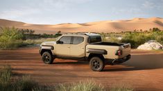 a pick up truck parked in the middle of a dirt road with sand dunes behind it