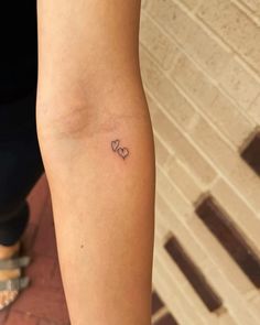 a small heart tattoo on the arm