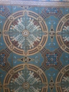 an artisticly designed tile wall in a bathroom with blue and brown designs on it