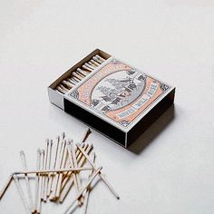 an open matchbox with matches on the floor next to it and several other matches