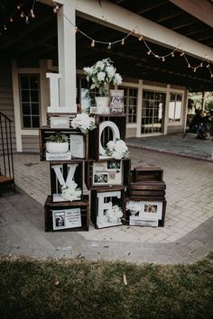 a stack of wooden crates sitting on top of a brick walkway next to a building