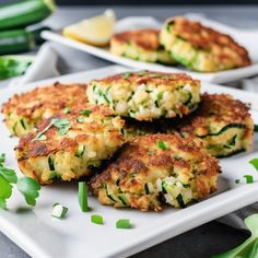 several crab cakes on a plate with lemon wedges and parsley in the background