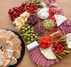 a platter filled with cheese, crackers, and other snacks on a table