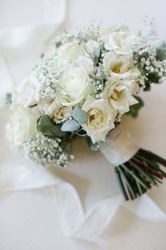 a bridal bouquet with white roses and baby's breath