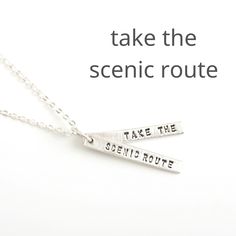 two silver necklaces that say take the scenic route