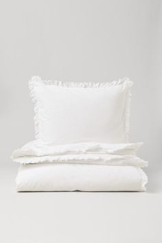 two white pillows on top of each other with ruffled edges and one pillow in the middle